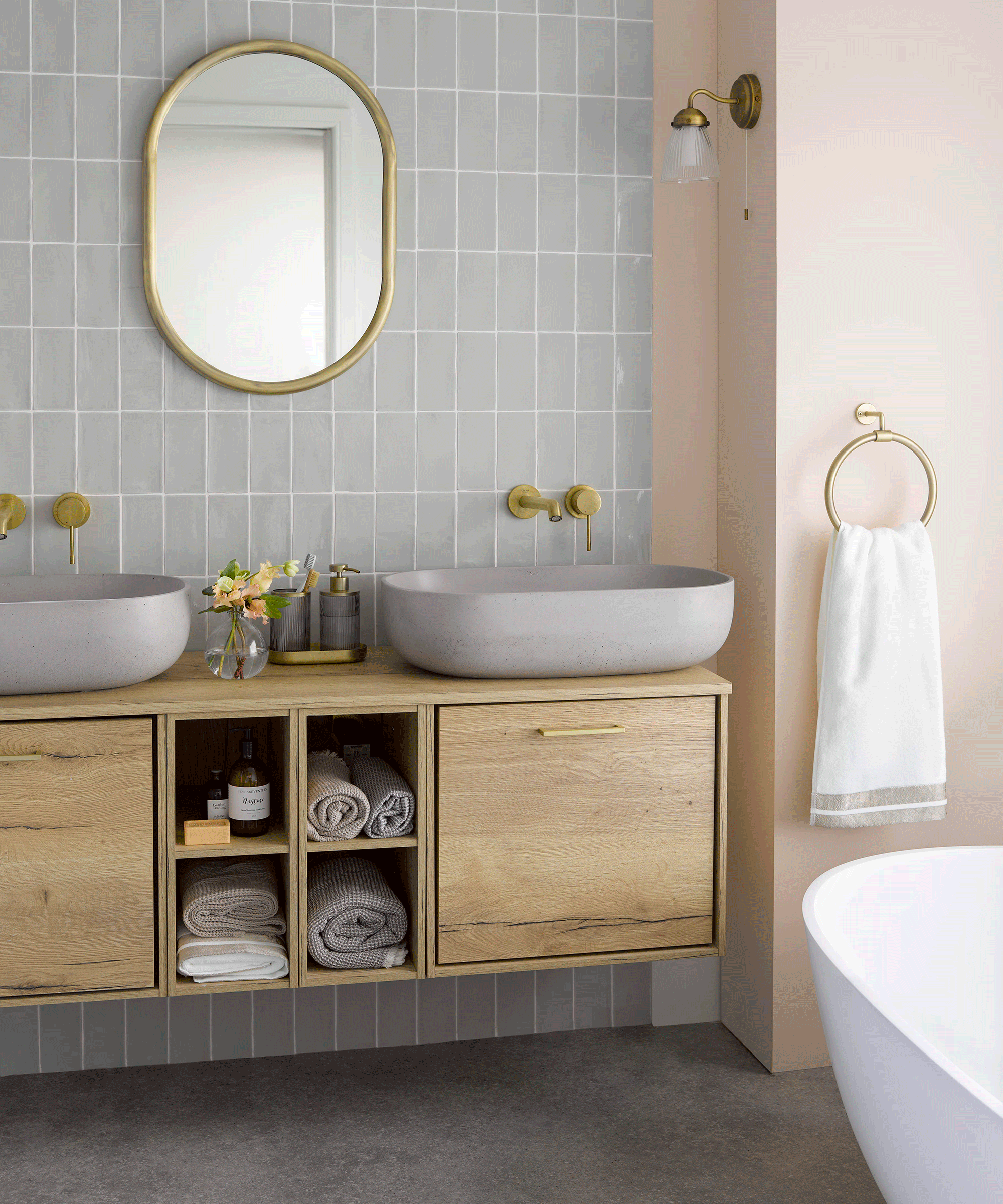 Bathroom with small wooden bathtub and freestanding white bathtub