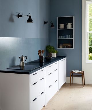 Blue kitchen with painted walls and white cabinets