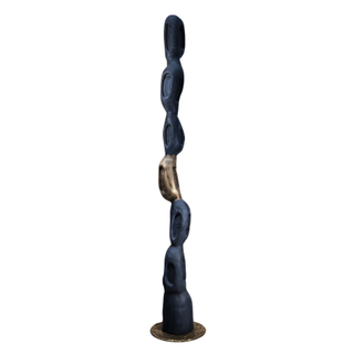 Black and gold totem sculpture comprised of stacked natural bean shape