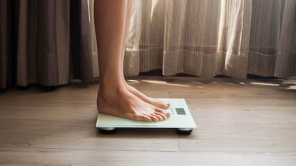 pair of feet stood on weighing scales