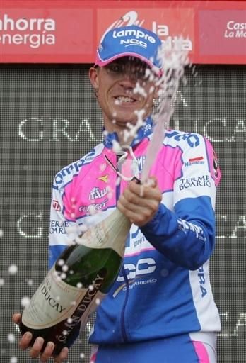 Damiano Cunego pops the cork on the champagne atop the Vuelta stage podium.