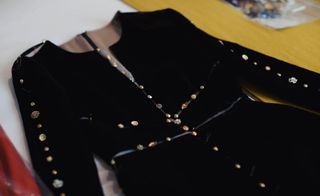 Black clothing piece with 18 carat gold-plated buttons