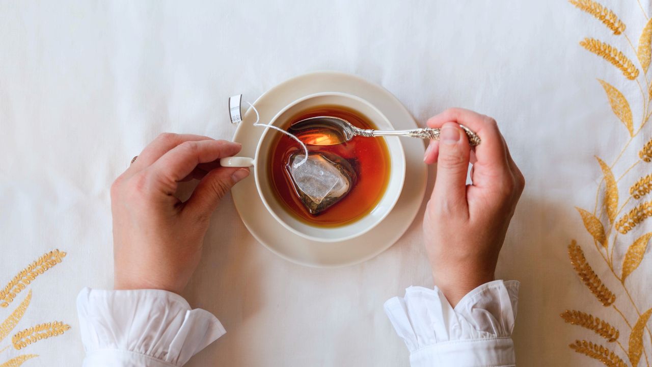 A woman stirring a cup of tea