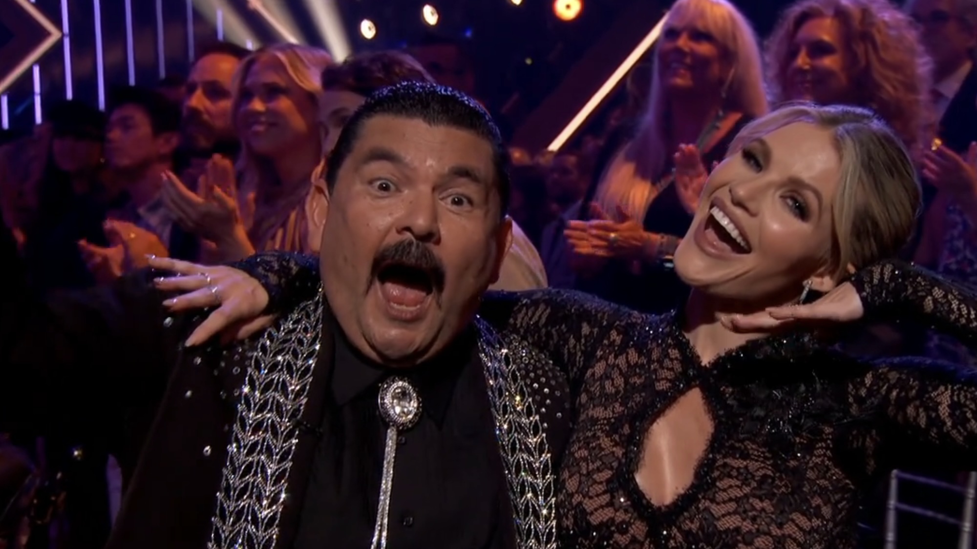 Guillermo and Witney posing with matching uniform before their segment plays on DWTS' Viral Music Night.