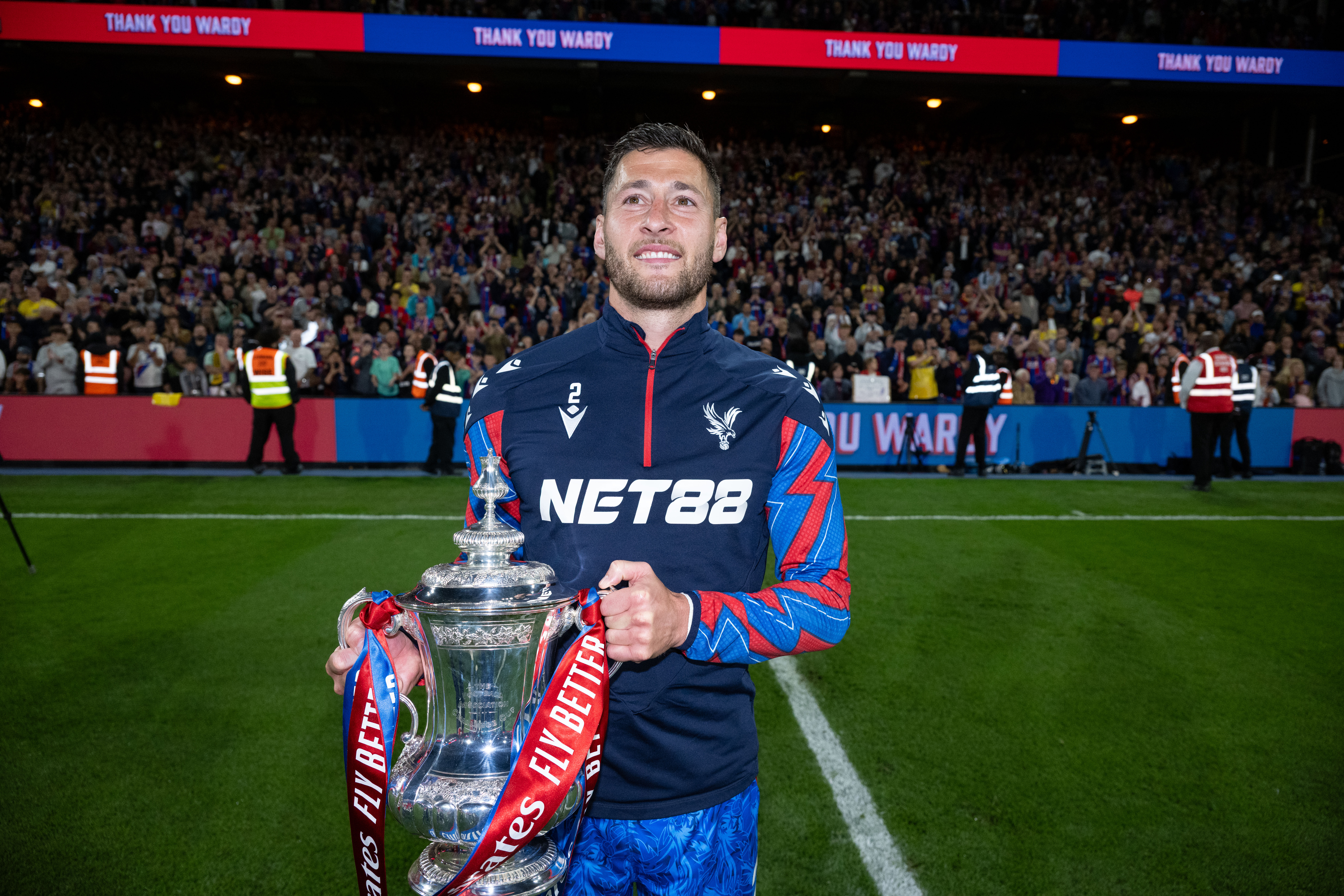 Joel Ward holds the FA Cup trophy ahead of Crystal Palace's Premier League game against Wolves in May 2025.
