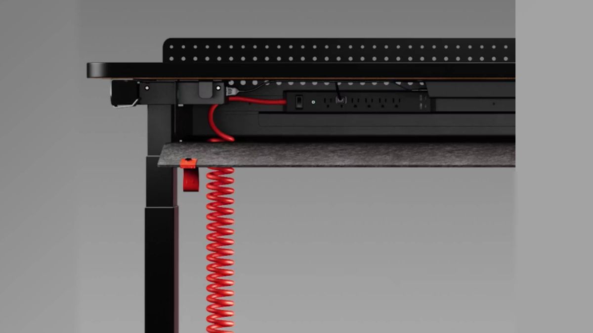 Close up of Herman Miller Coyl under wiring with red wire leading to extension lead.