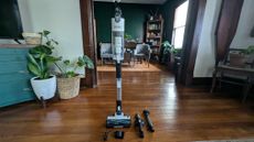 Levoit LVAC-200 cordless vacuum, standing upright, next to supplied accessories, in reviewer's home