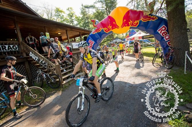 Jon Firth, duo men's GC leader, rides through camp at check in.