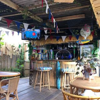 bar counter with bunting flag and table with chairs and trailing plants
