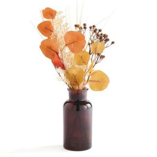 A brown vase full of autumnal faux flowers