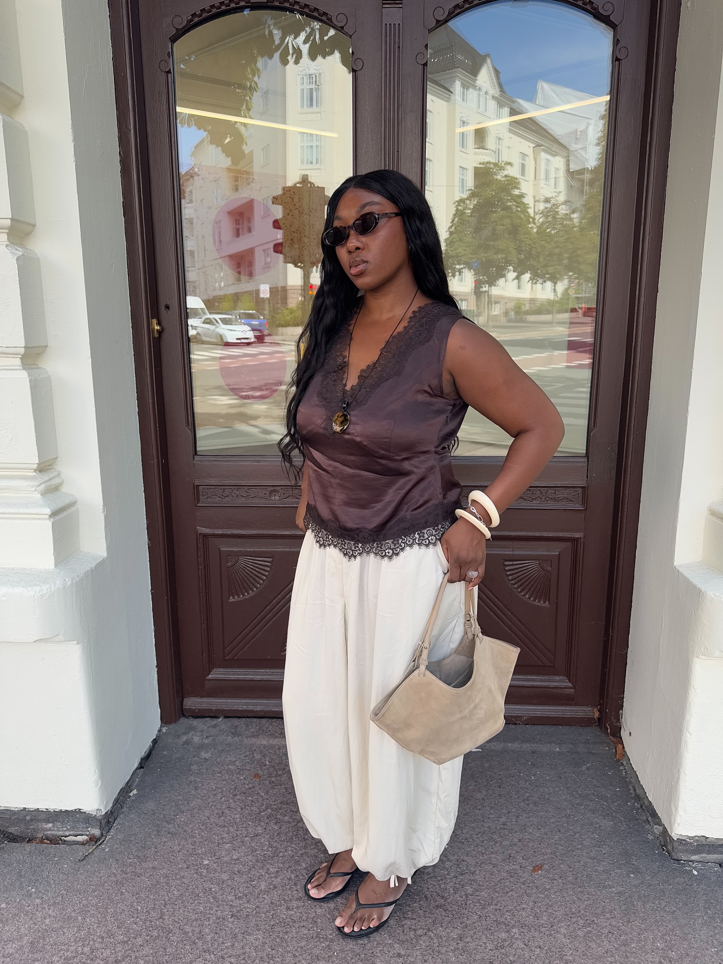 An image of @nnennaechem wearing a lace-trim tank top.