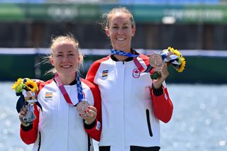 Caileigh Filmer, left, holds up her 2020 Tokyo Olympics bronze medal for rowing.