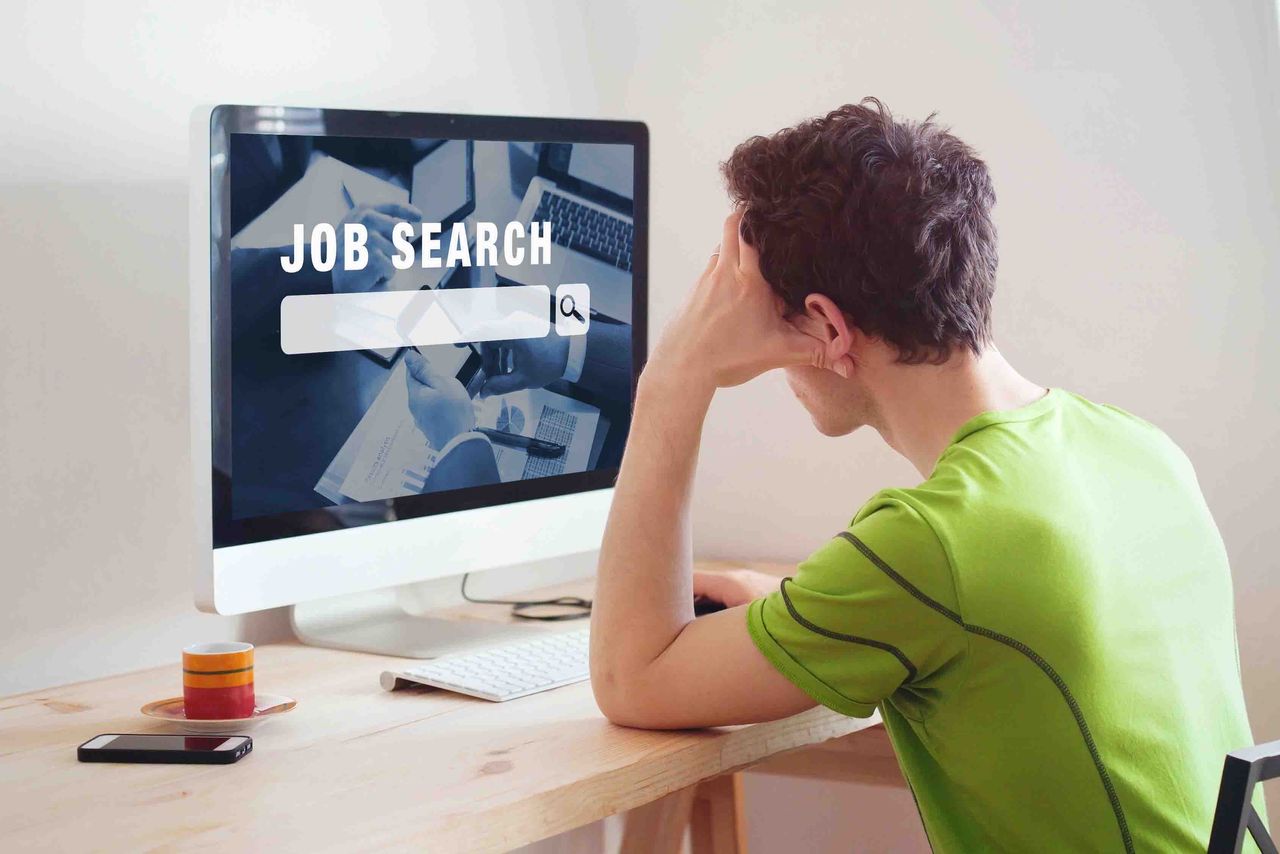 photo of a man looking at a computer screen with the words &amp;quot;job search.&amp;quot;