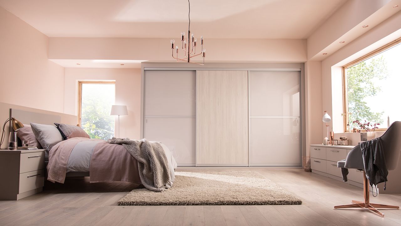 Neutral pale pink bedroom with large grey sliding door wardrobe