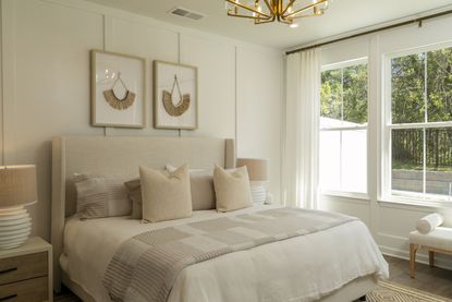 The Master Bedroom with a bed covered in hotel pillows in the Rutgers Model Townhome at Four Seasons at Virginia Crossing