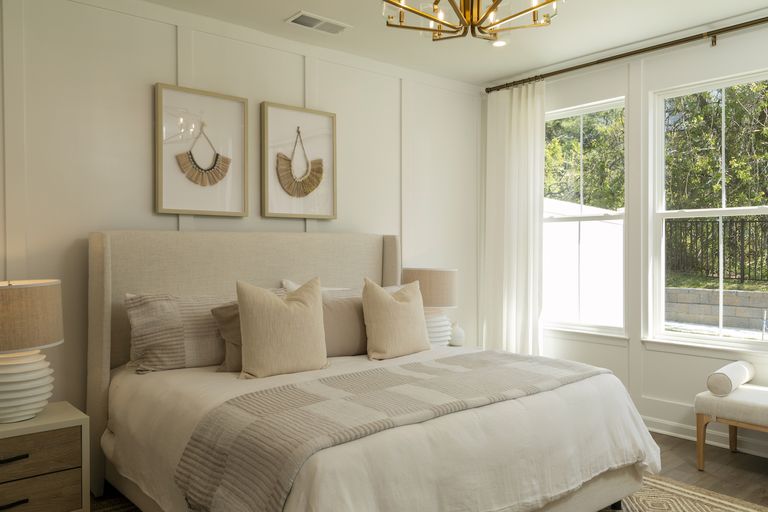 The Master Bedroom with a bed covered in hotel pillows in the Rutgers Model Townhome at Four Seasons at Virginia Crossing
