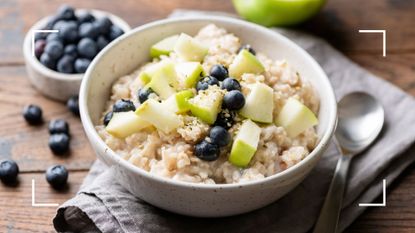 Bowl of apple and cinnamon porridge in white ceramic bowl with metal spoon, to represent food on the Cambridge Diet plan