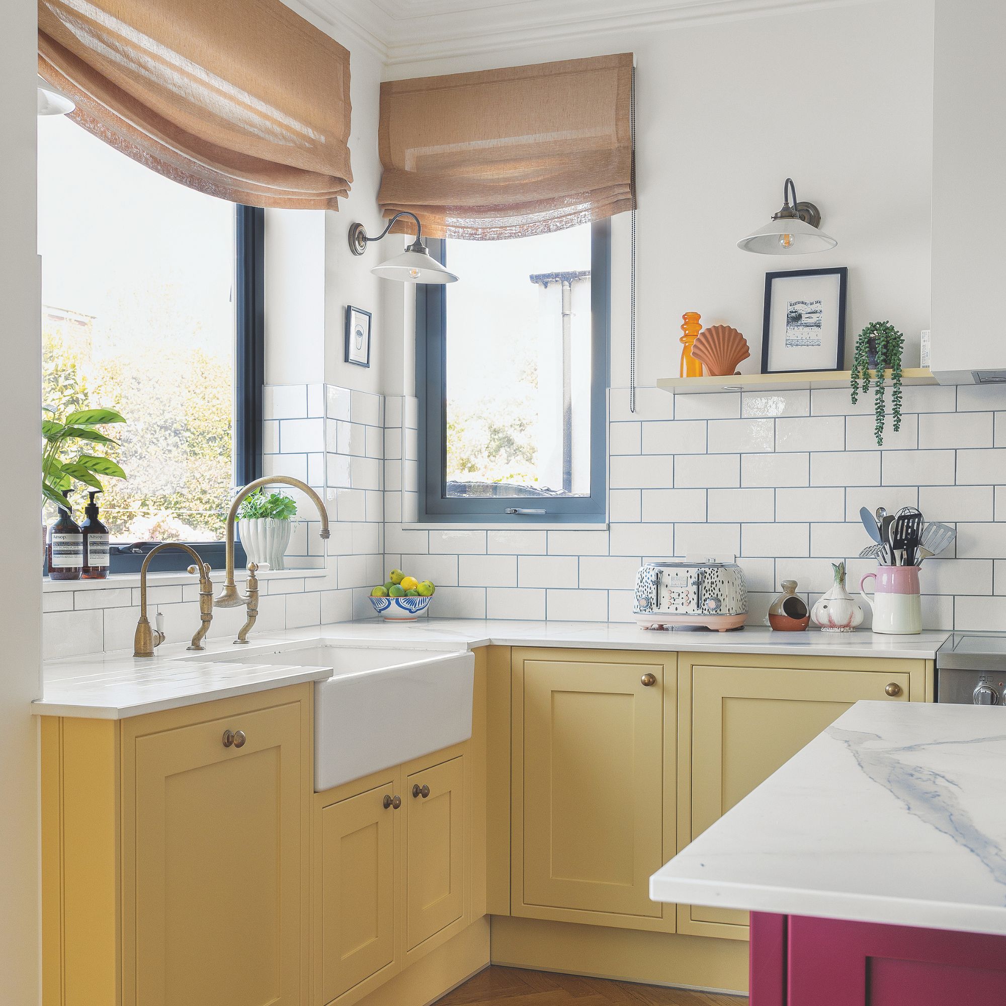 White painted and tiled kitchen with yellow bottom cabinets and a white worktop
