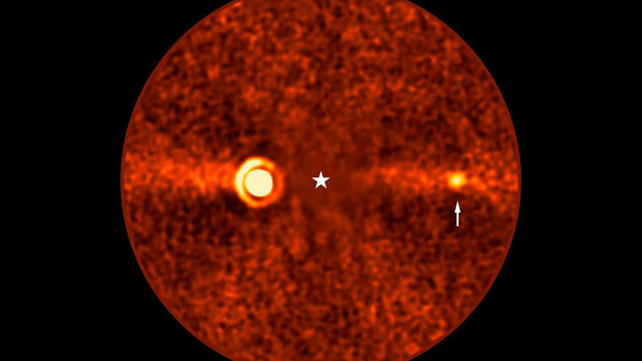 This image, taken with ESO’s Very Large Telescope (VLT) shows Beta Pictoris d, a new planet found orbiting the star Beta Pictoris. The star is at the centre of the frame, and was subtracted when processing the data, revealing the environment around it. The new planet, indicated with an arrow, is the third one found around this star. The other two are Beta Pictoris b –– the bright source to the left, and Beta Pictoris c, orbiting much closer to the star and not seen here. The image was taken with the ERIS instrument at the VLT. Based on its infrared brightness and colour, the new planet appears to be a gas giant, about 2.4 times more massive than Jupiter. The diffuse horizontal band in this image is a debris disc around the star, seen here edge-on, the leftover material of planetary formation.