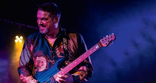 Nicolas Meier takes a solo on his Ernie Ball Music Man John Petrucci signature model – he wears a blue shirt with a graphic pattern,