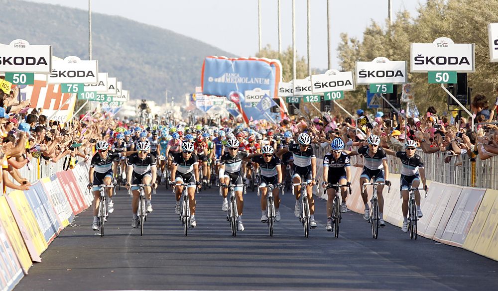 The riders of Leopard-Trek team and Tyler Farrar cross the finish line together in tribute to Wouter Weylandt