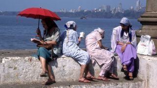 Four women sit by the sea and pray