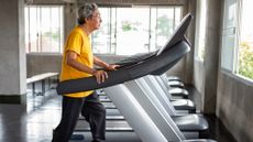 Senior man walking on treadmill in a gym