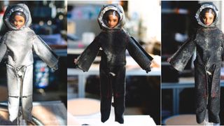 A trio of Barbie dolls wearing makeshift spacesuits. 
