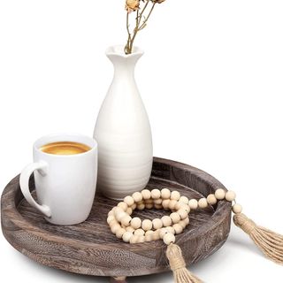 Round rustic wood serving tray with coffee mug, vase, and wooden beads