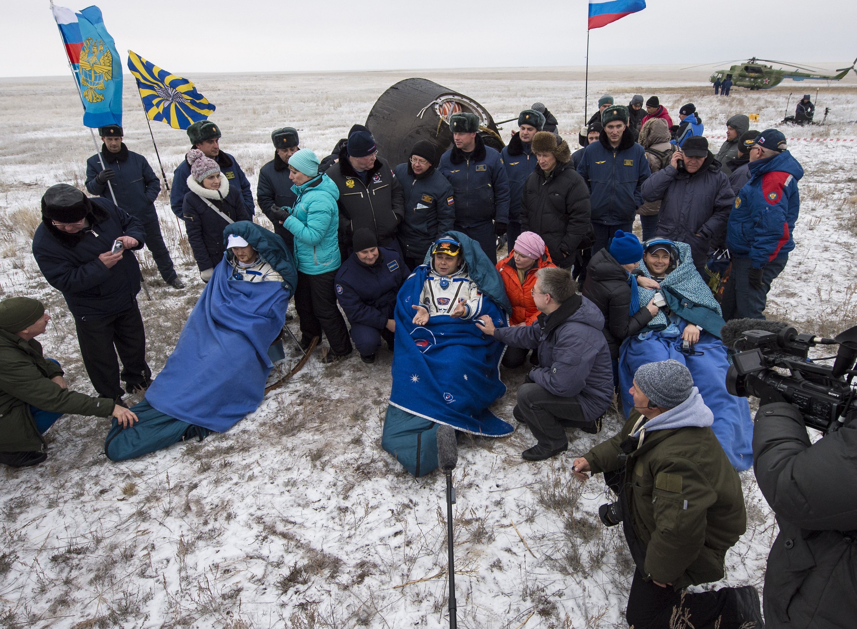 Alexander Gerst (left), Maxim Suraev and Reid Weisman are seen seated in front of their Soyuz TMA-13M spacecraft after landing on the snow-covered steppe of Kazakhstan, Nov. 9, 2014.