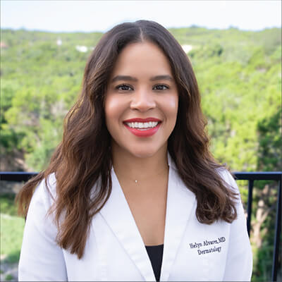 a photo of a woman doctor with brown hair wearing a white coat