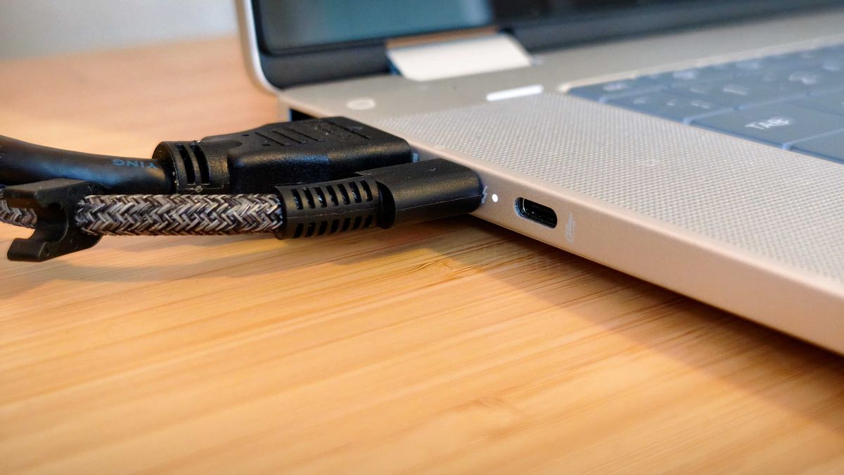 A silver HP Omnibook X Flip 16 2-in-1 laptop on a wooden desk