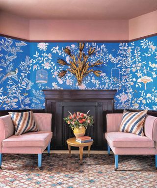Pink and blue sitting room with patterned wallpaper and seating