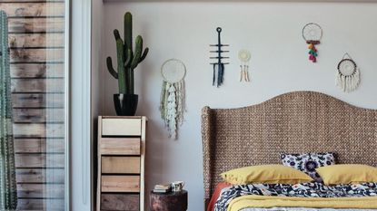 A bedroom with a cactus placed atop a nightstand