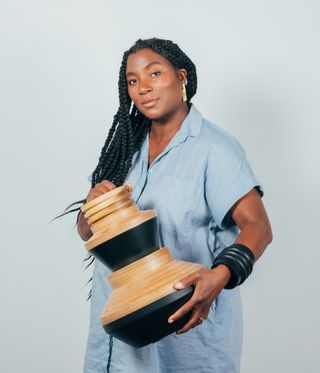Designer Simone Brewster holding a wooden vessel