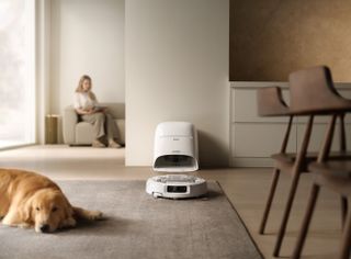 DJI Romo robot vacuum and dog and woman