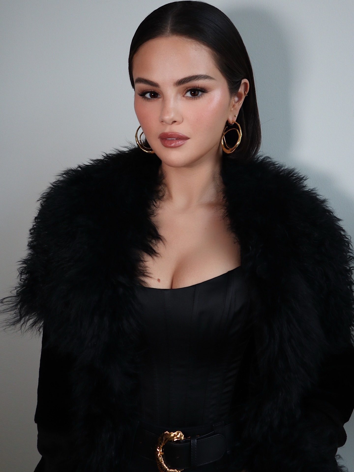 Selena Gomez with a glossy straight bob tucked behind her ears