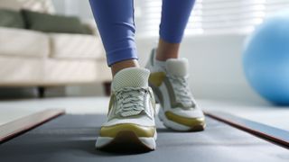 Woman walking on walking pad at home