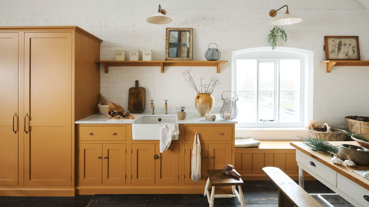 rustic kitchen with white walls and dark yellow cabinets