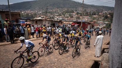 Residents gather to look at cyclists competing during the final stage of the 14th Tour du Rwanda on 27 february 2022, in Kigali.