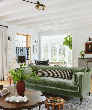 light and airy living room with white walls and green velvet sofa