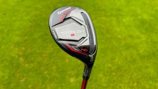 TaylorMade Stealth 2 HD Hybrid held aloft to reveal its red and black colorway