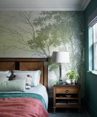 colorful bedroom with green tree mural, wooden bed and teal painted wall
