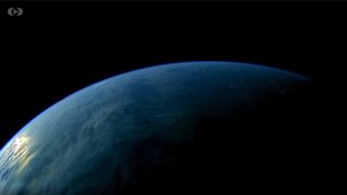 a view of blue Earth rising from below against black shadowy space.