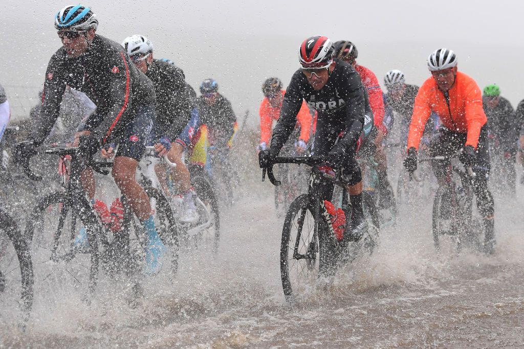 Riders push on through one of the large puddles on the course