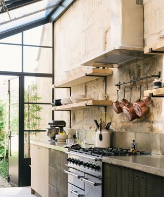 A solarium kitchen created using crittall windows on the walls and ceiling