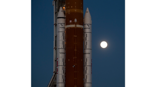 The moon glows behind the Space Launch System of Artemis 1 on March 17, 2022.