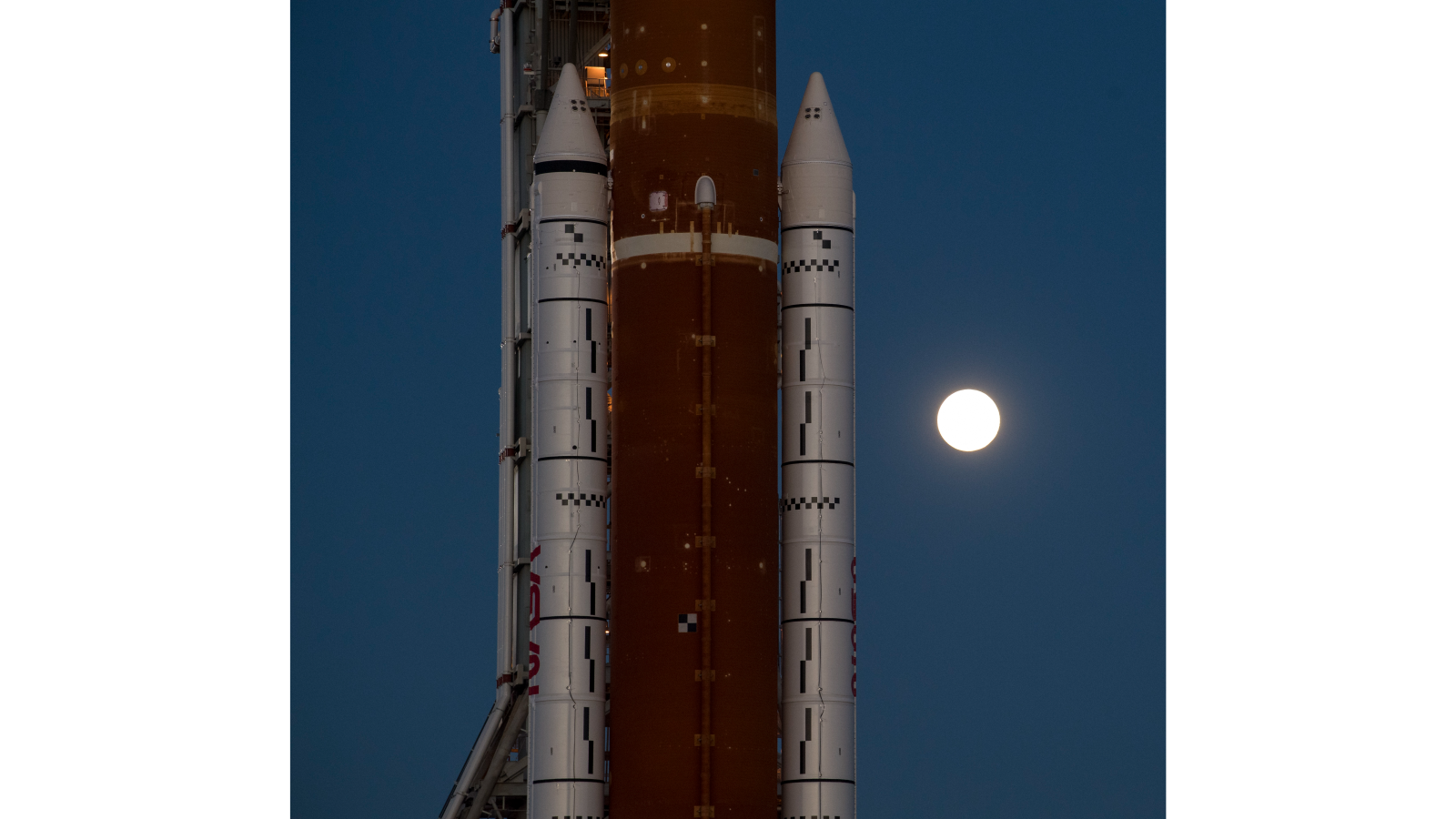 The moon glows behind the Space Launch System of Artemis 1 on March 17, 2022.