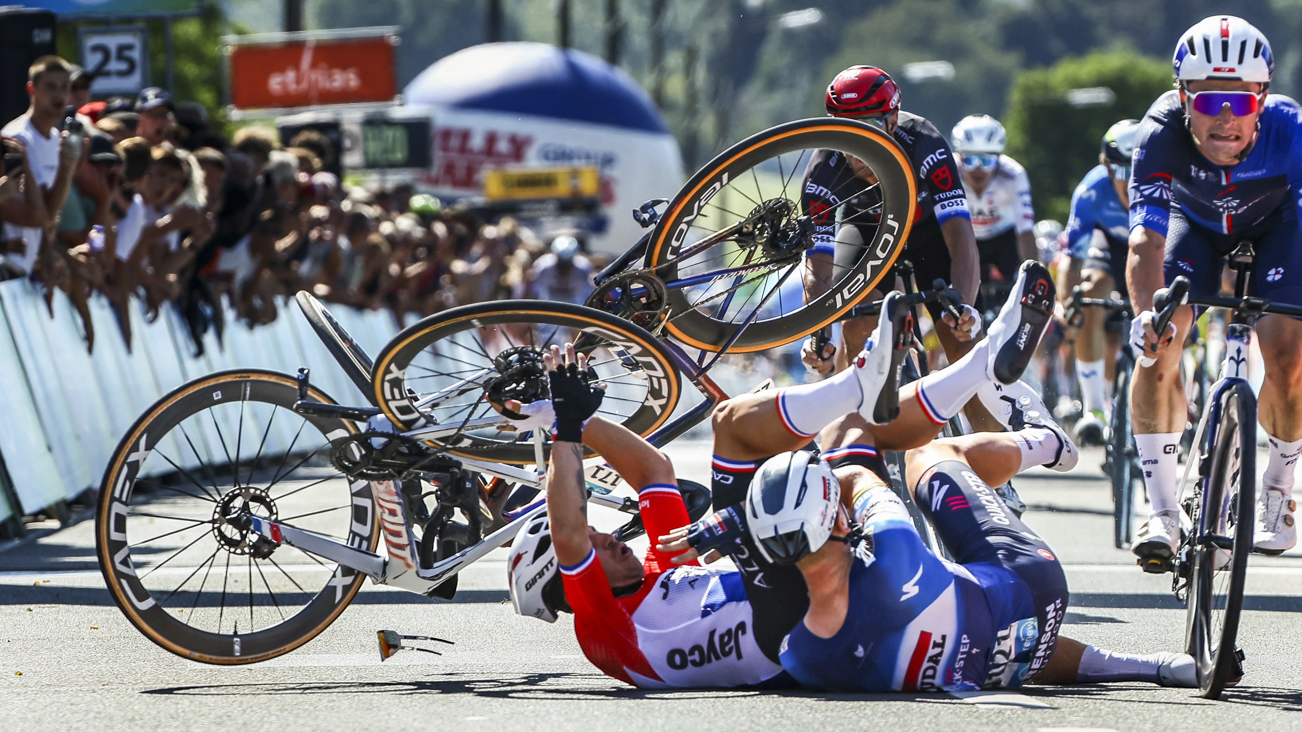 Team Jayco Alula's Dutch rider Dylan Groenewegen (L) and Soudal Quick-Step's Belgian rider Tim Merlier (2ndL) crash at the end of the first stage of the Renewi Tour