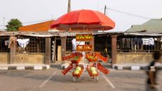 metal market crate stall with red umbrella in parking lot